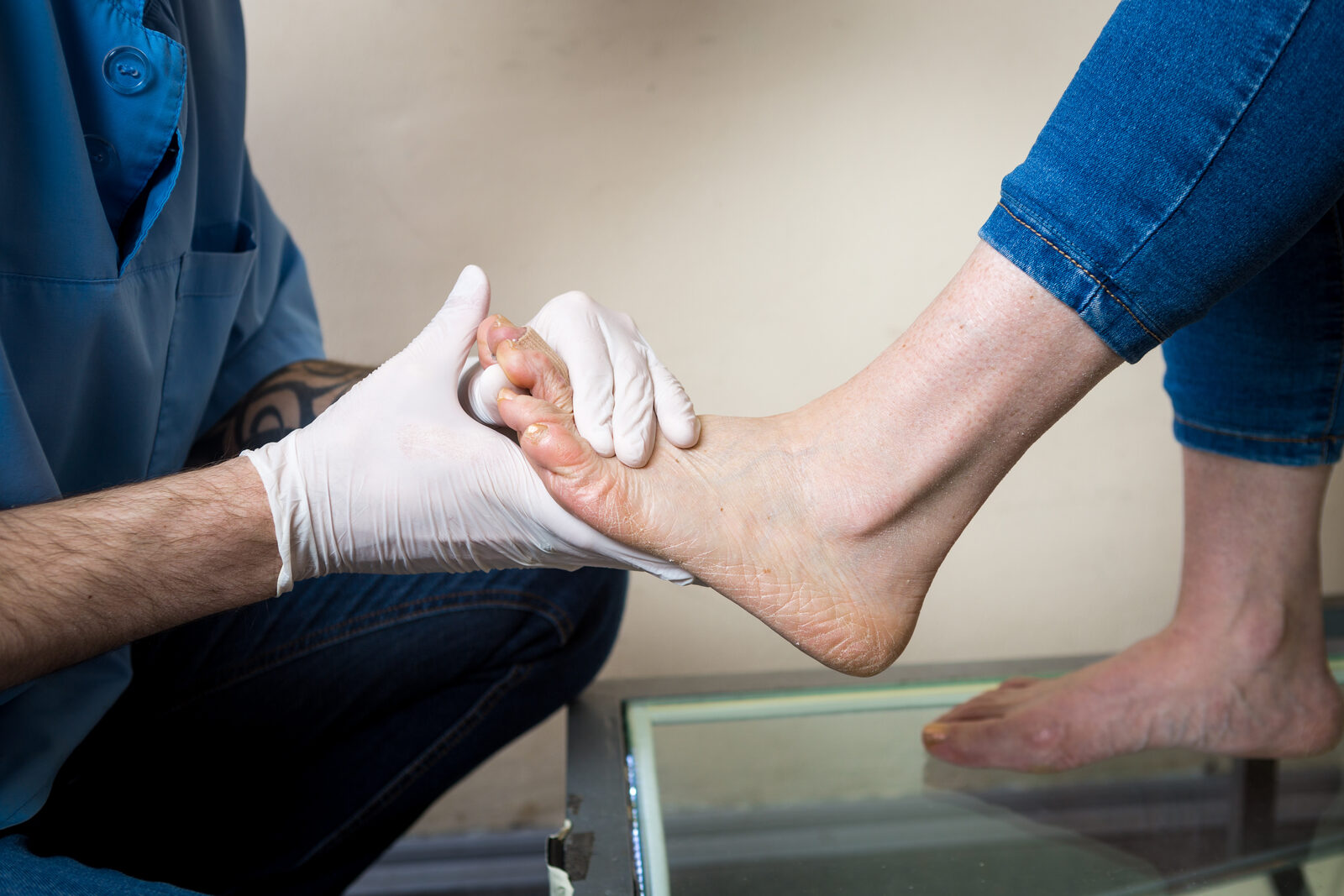 A clinician performing a hands-on foot and ankle assessment
