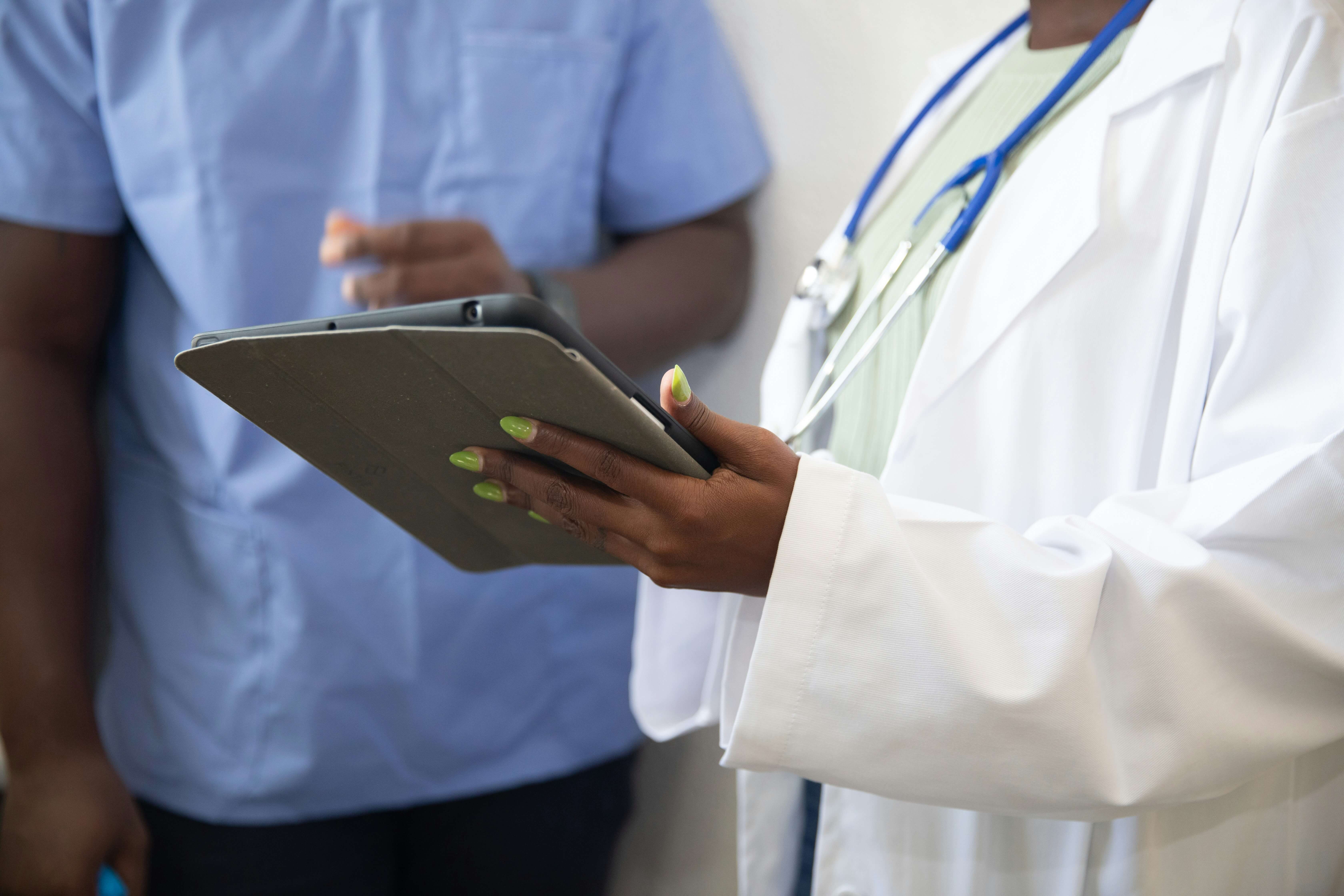 Two clinicians reviewing a case together on a tablet