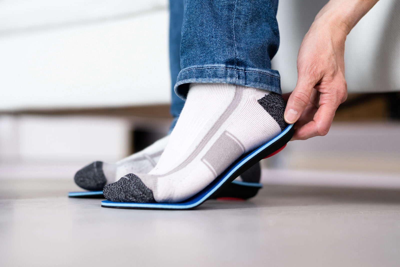 A custom orthotic insole being fitted against a sock
